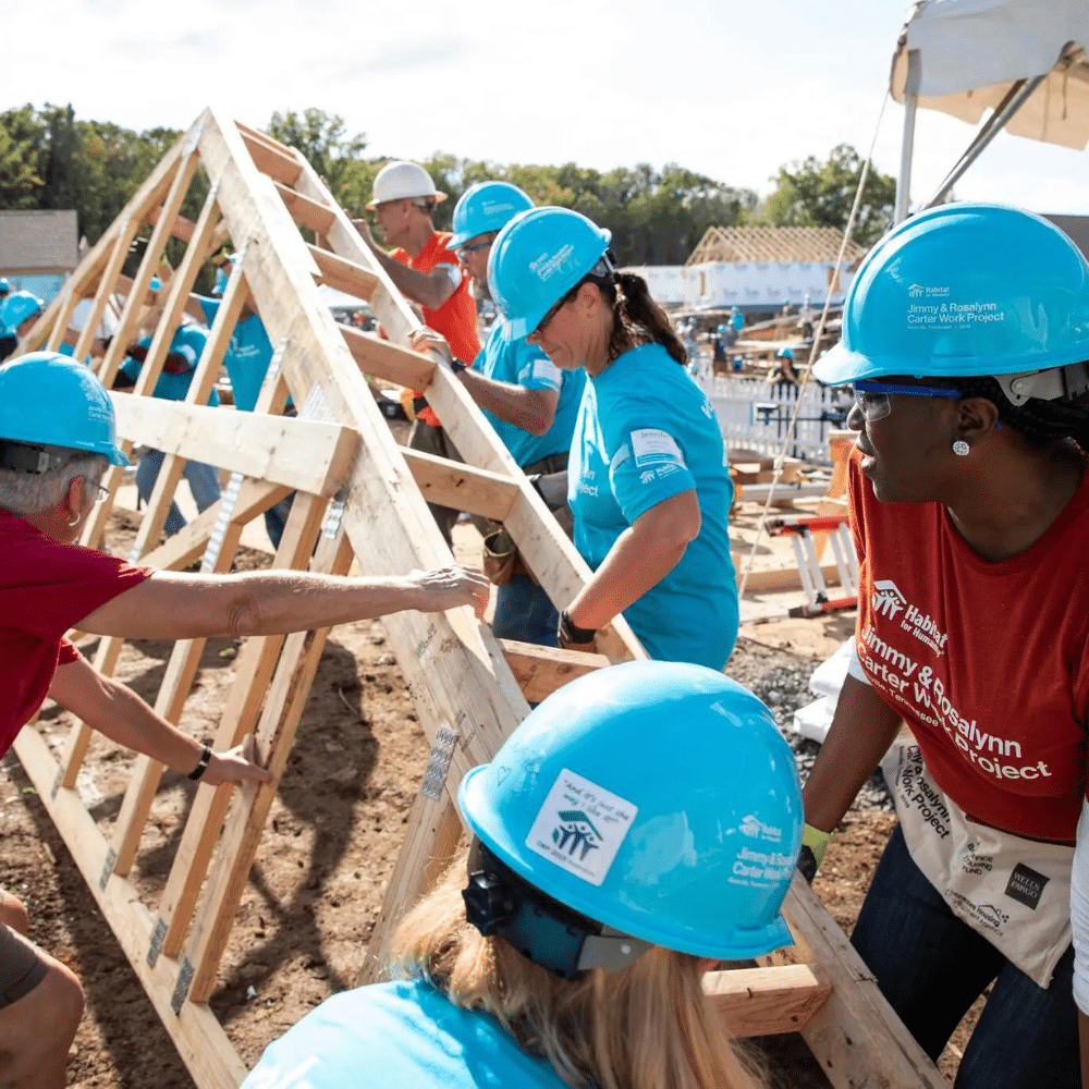 Habitat for Humanity Women Build volunteer in pink shirt hammering a nail during a Golden Crescent home build