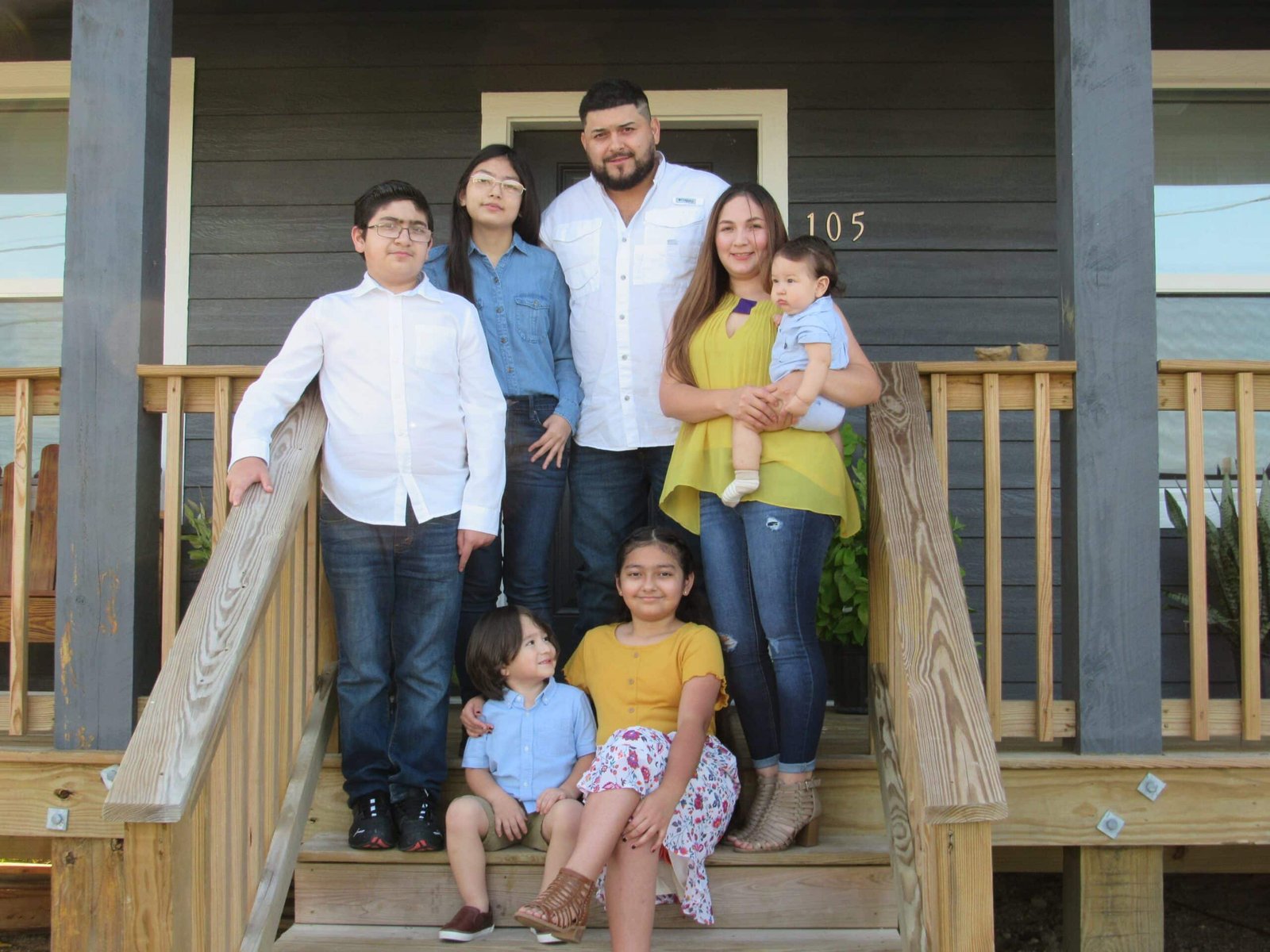 New happy family posing with their new home