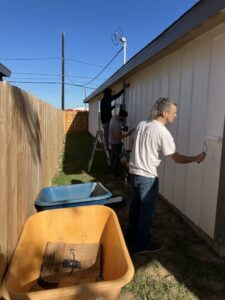 Volunteers painting the exterior siding of a house during a Golden Crescent Habitat for Humanity repair project