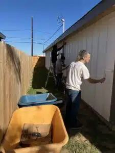 Volunteers painting the exterior siding of a house during a Golden Crescent Habitat for Humanity repair project