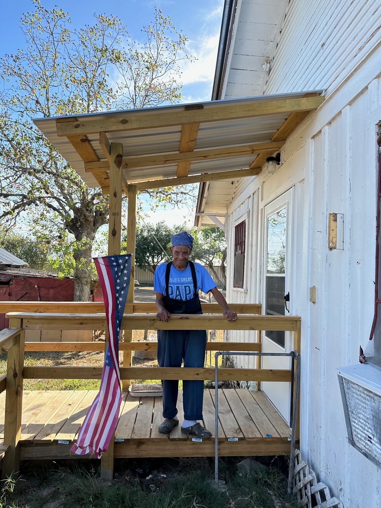 Older black woman next to american flag